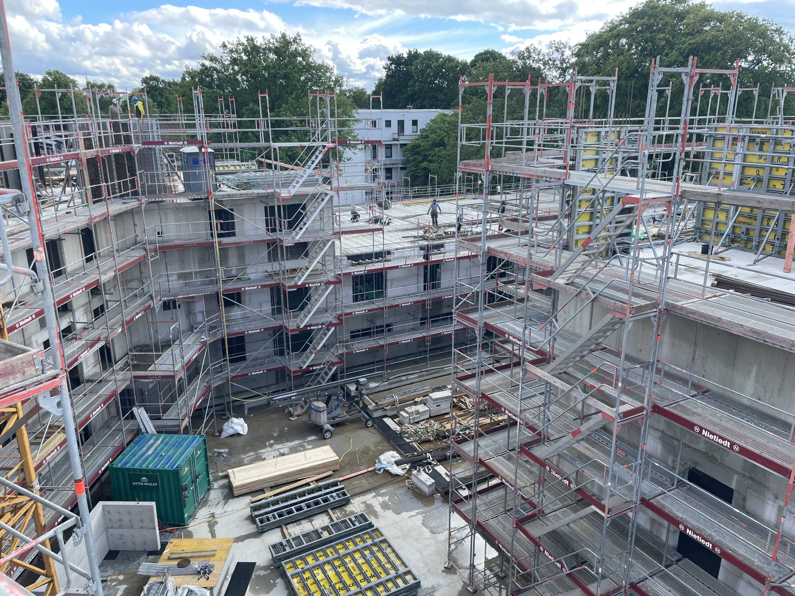 Baustelle eines mehrstöckigen Gebäudes mit Gerüsten und Baumaterialien